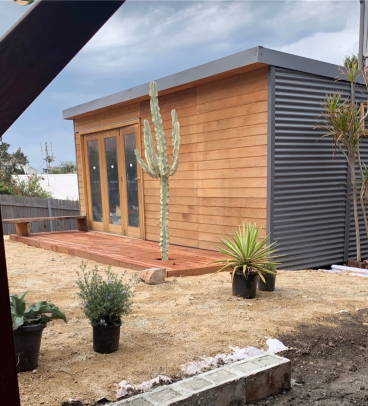 "The Haven" backyard pod, 6110mm x 3090mm, 18.8m2, with bifold doors, western red cedar on the front, and colorbond walls and roof. A spacious and stylish solution for creating a garden studio, she shed, backyard pod, or backyard office.