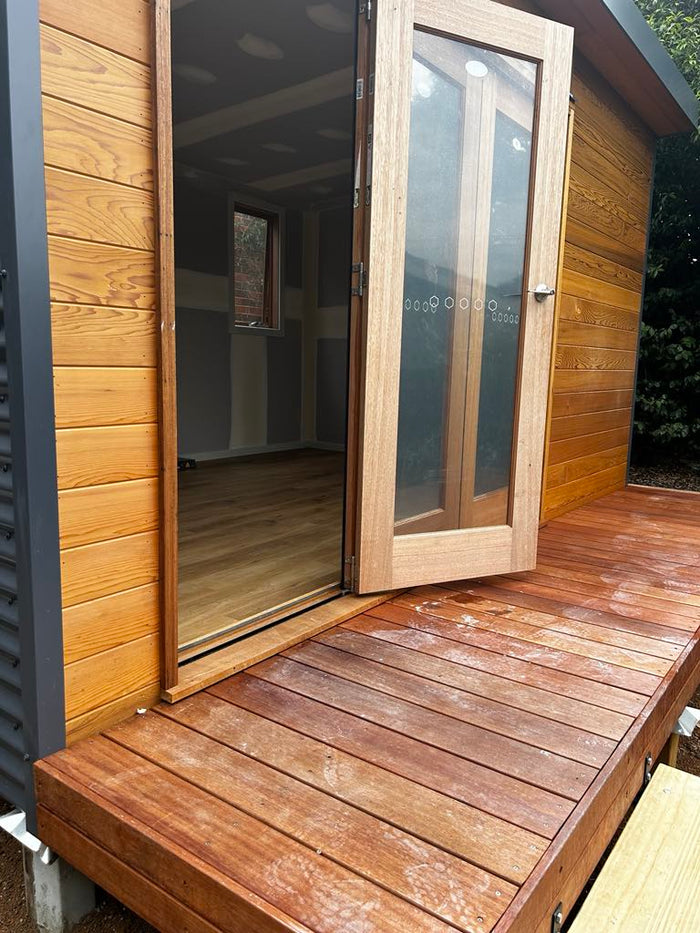 Merbau timber deck close-up at front of backyard studio, highlighting warm tone and natural finish.